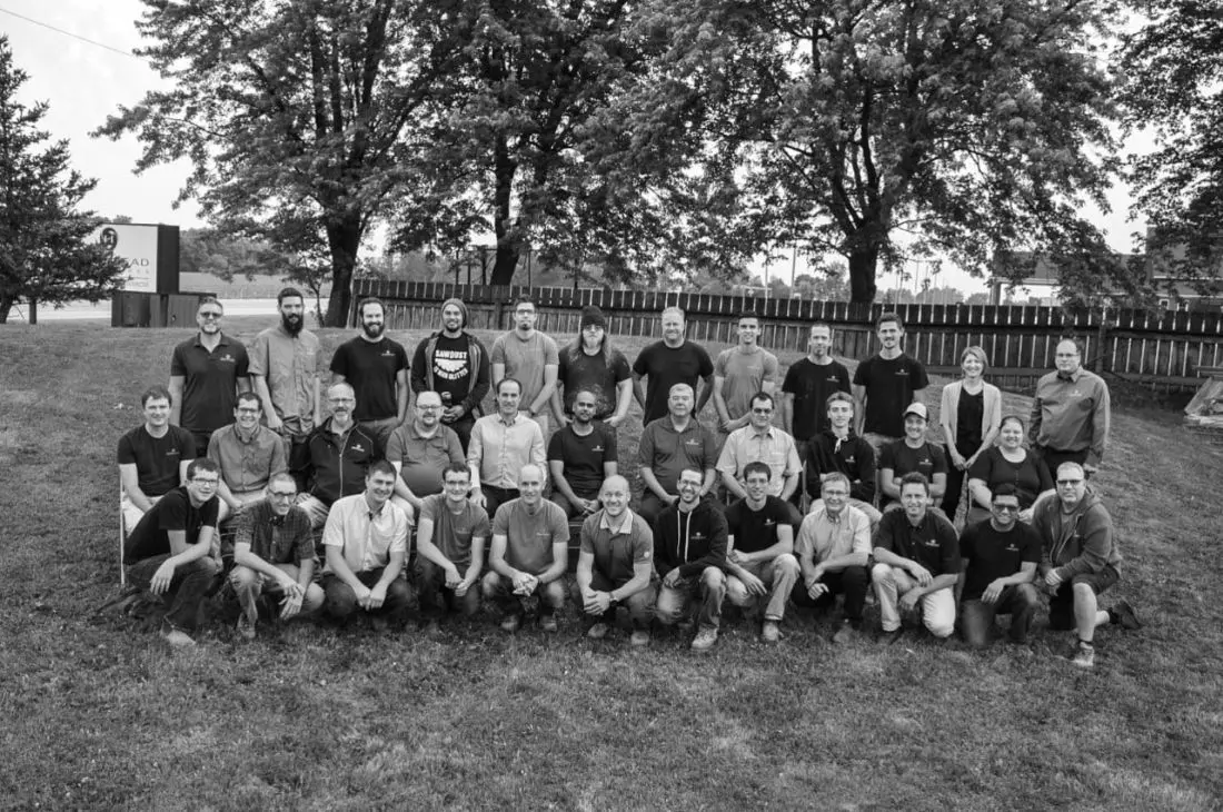 The Homestead Woodworks team posing outdoors, a group of professional craftsmen specializing in custom woodwork, cabinetry, and millwork.